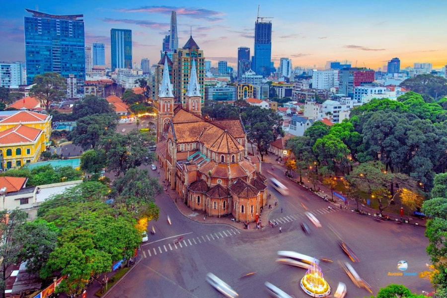 Notre Dame Cathedral surrounded by Saigon city skyline at sunset – Auasia Travel